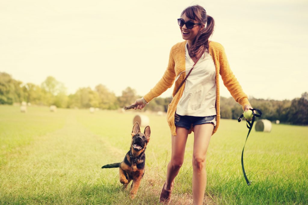 A woman in a field with her German shepherd pup