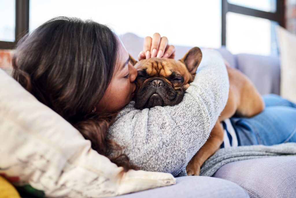 Woman hugging pug puppy.